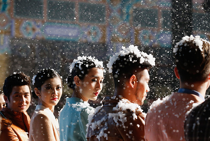 24 hours in pictures: Model are seen covered with artificial snow flakes Beijing