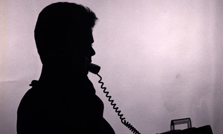 Silhouette of man in shadow talking on the telephone.