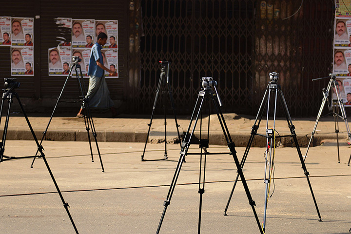 24 hours: Dhaka, Bangladesh: A pedestrian passes tripods 