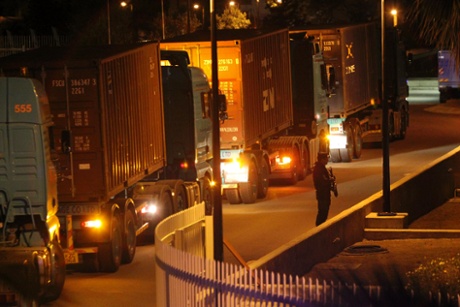 A policeman stands guard in front of trucks carrying containers at the Central Bank in Nicosia March 27, 2013.