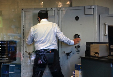 An employee opens a safe inside a Bank of Cyprus branch before it opened in Nicosia March 28, 2013.