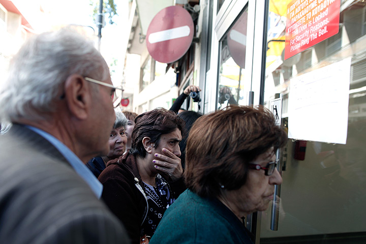 Cyprus banks: People wait outside the entrance of a Laiki branch