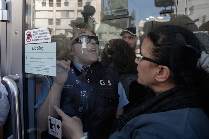 Cyprus banks: A customer argues with a security guard at of Laiki Bank