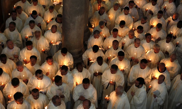 Roman Catholic clergymen hold candles as they circle the Anointing Stone during the Holy Thursday mass at the Church of the Holy Sepulchre in Jerusalem's old city ahead of Easter celebrations.