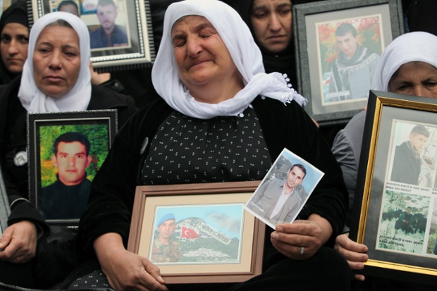 Family members of 34 Turkish Kurdish civilians, who were killed in Dec. 2011 in a botched raid on the Turkey-Iraq border by Turkish military jets, hold their pictures as they stage a protest outside Turkey's parliament in Ankara.