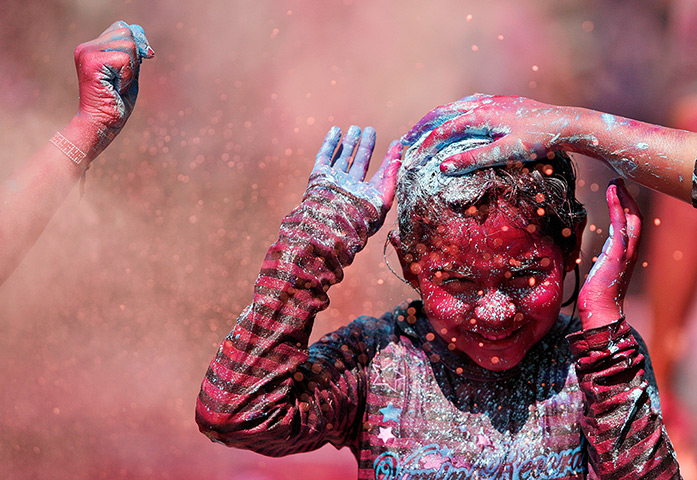 24 hours: Chennai, India: A child reacts as coloured powder is smeared