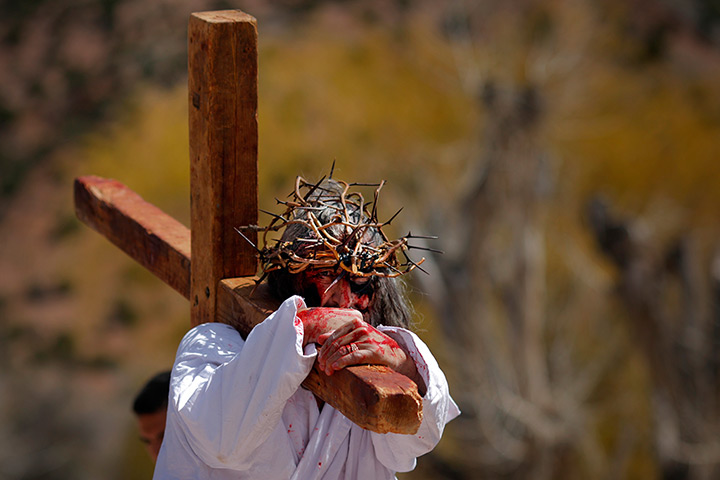 24 hours in pictures: Chimayo, New Mexico: A man playing the role of Jesus carries a cross during