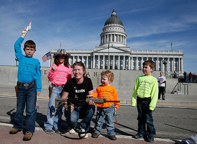 24 hours in pictures: Siri Davidson and her children poses with her AR-15