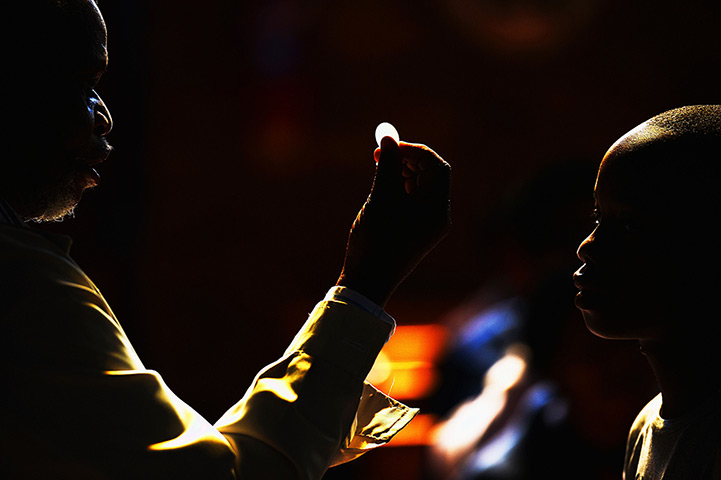 24 hours: Soweto: A child receives communion at Regina Mundi church