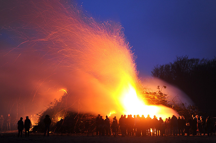 24 hours: Hellwege, Germany: People stand by an Easter fire 