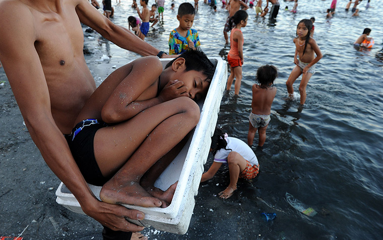 24 hours: Manila, Philippines: A boy is carried in a polystyrene box