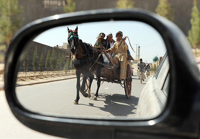24 hours: Herat, Afghanistan: Villagers are reflected in a vehicle's mirror
