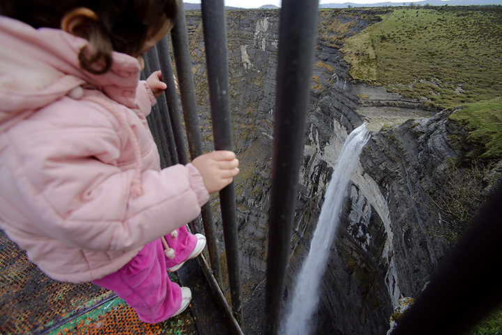 24 hours: Osma, Spain: A young girl looks at the Salto del Nervion waterfall