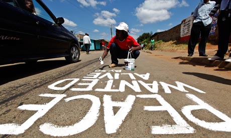 Kenyan street artist Solo7 paints message of peace near a polling station in Kibera slum of Nairobi