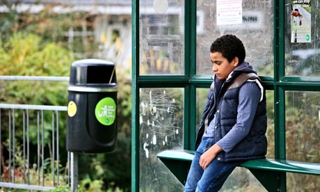 Little boy sitting at bus stop