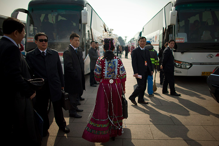 24 hours in pictures: A  delegate, dressed in ethnic attire, walks back to her bus