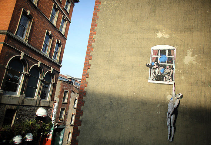 24 hours in pictures: A mural by the street artist Banksy which has been defaced by blue paint 