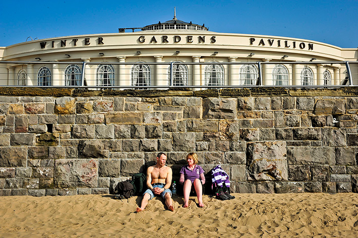 Spring weather UK: A couple soak up the sun on the beach sunshine at Weston-super-Mare