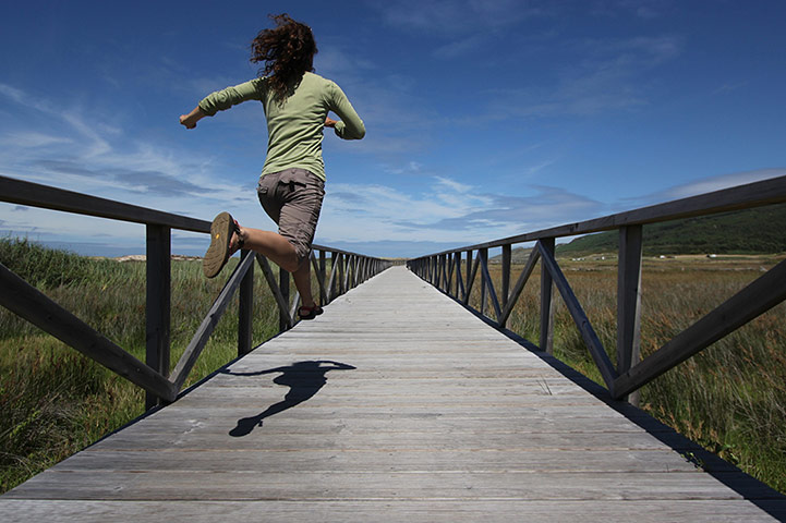 Inpics-leap: girl running along wooden bridge