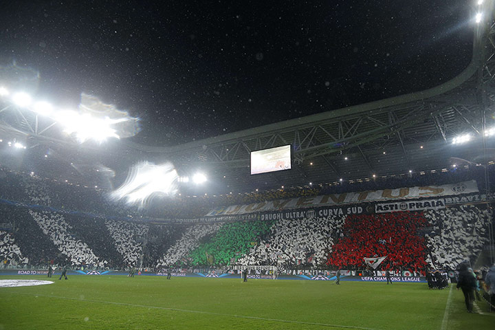 Wed champions league: Supporters wave flags under an heavy rain at the Juventus Stadium