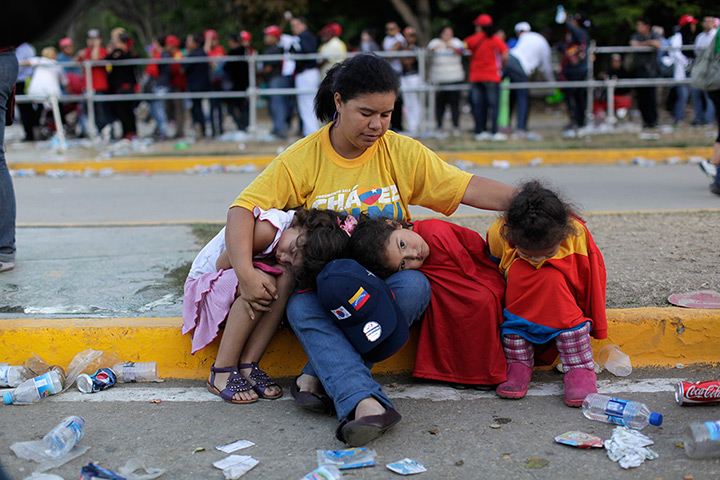 Hugo Chavez funeral: A woman sits with her children