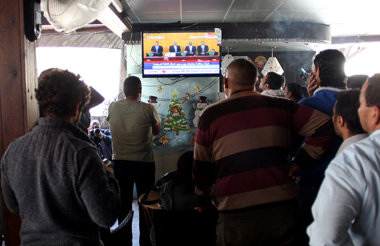 Men in a coffee shop in Port Said, Egypt, watch the televised court verdict