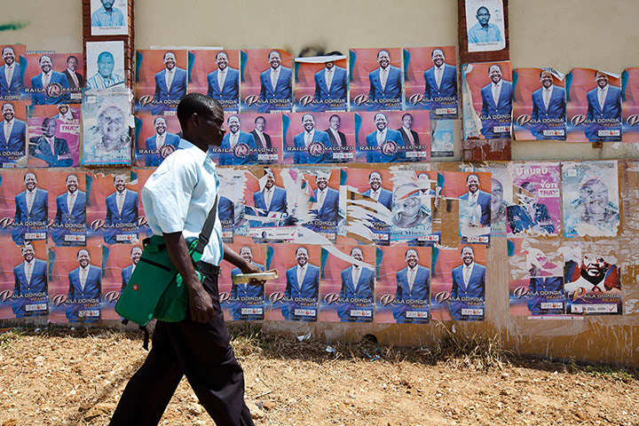 Kenya: A man walks past a wall pasted with campaign posters