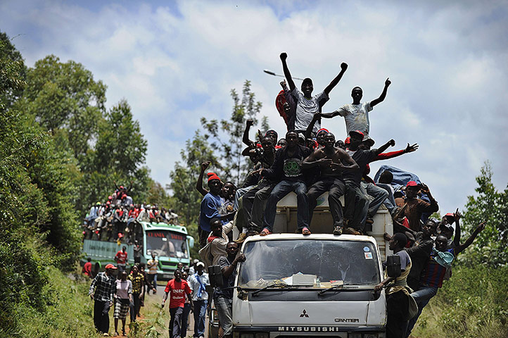 Supporters of presidential candidate Uhuru Kenyatta celebrate his victory as they ride through his hometown in Gatundu