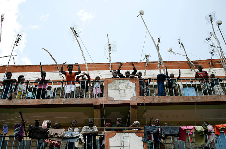 Supporters of the Kenyan prime minister, Raila Odinga, look out from the balconies of a building in the Mathare slum 