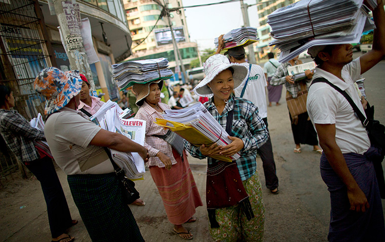 24 hours: Rangoon, Burma: Newspaper sellers wait for a bus 