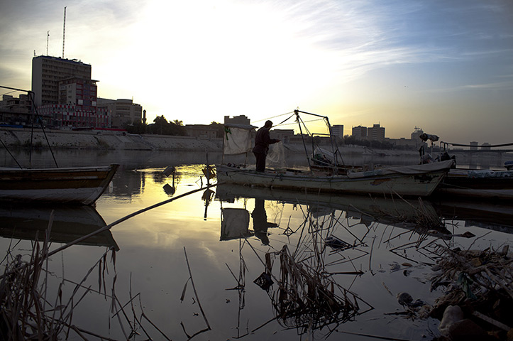 24 hours: Baghdad, Iraq: A man fishes from a boat on the Tigris river 
