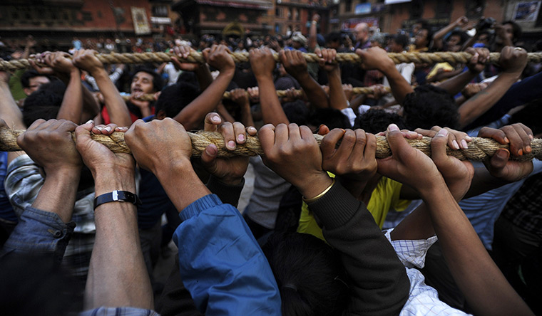 24 hours in pictures: Nepalese Hindu devotees pull a wooden chariot