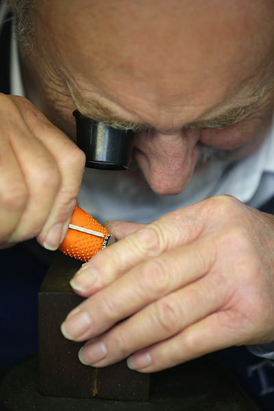 FTA: Christopher Furlong: A craftsman hand engraves the edge of a medal