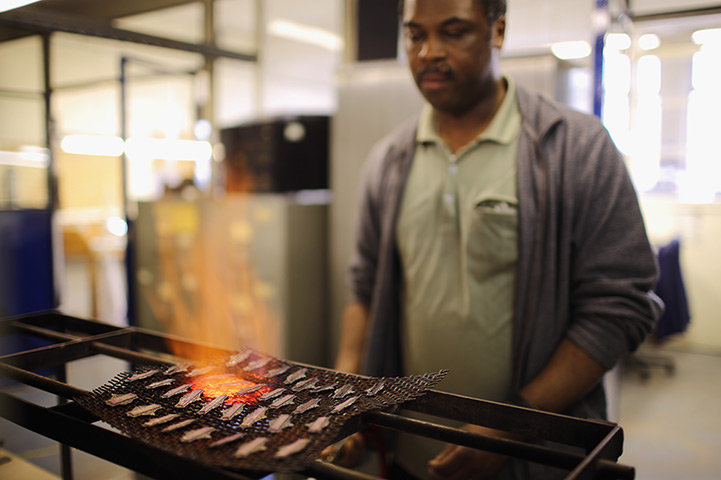 FTA: Christopher Furlong: A craftsman heats enamels on badges 