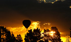 Hot air balloon in flight at sunset
