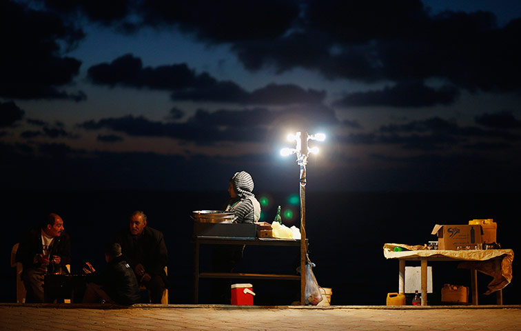 24 Hours: A Palestinian vendor sells corns on a beach in Gaza City
