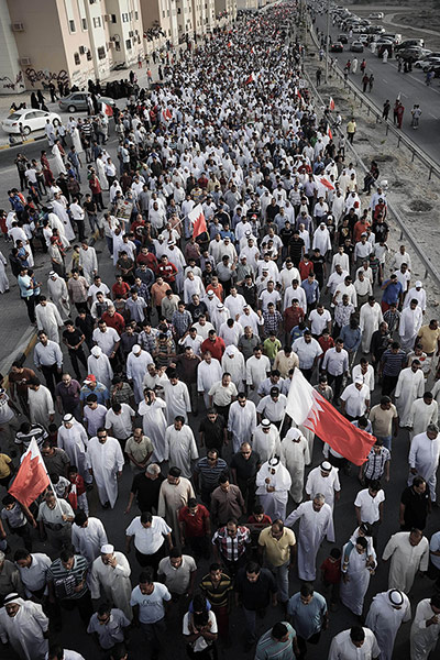 24 Hours: Bahraini protestors hold up national flas during an anti-regime rally