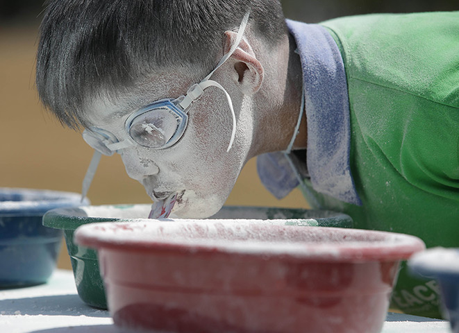 24 hours: Quezon, Philippines: A boy gets a chip from a basin filled with powder
