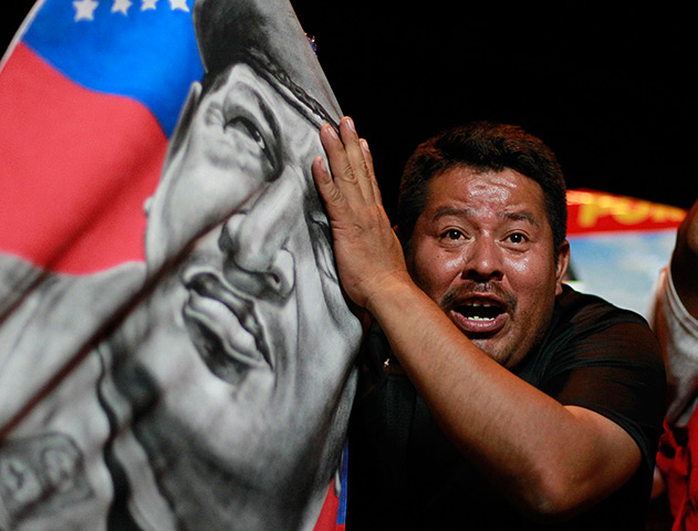 Venezuela results: A supporter of Nicolas Maduro holds a Hugo Chavez banner