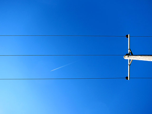 Your Pictures - parallel: lines of telegraph pole with plane flying overhead against blue sky