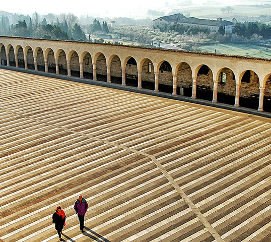 Your Pictures - parallel: two people walking across a medieval square in Italy