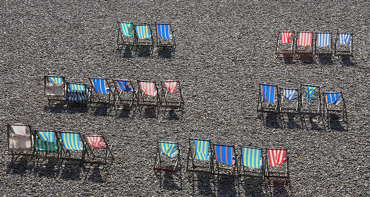 Your Pictures - parallel: deckchairs in different colours against gravel beach