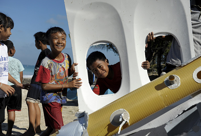 24 hours: Denpasar, Indonesia: Children play with parts of Lion Air Boeing 737 plane