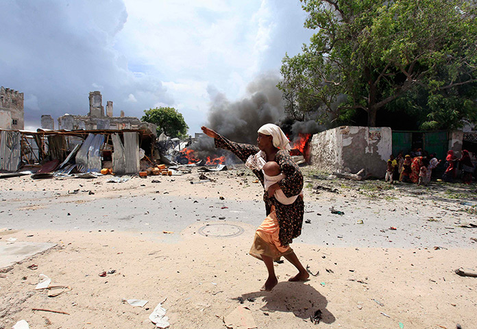 24 hours: Mogadishu, Somalia: A woman runs to safety near the scene of a blast