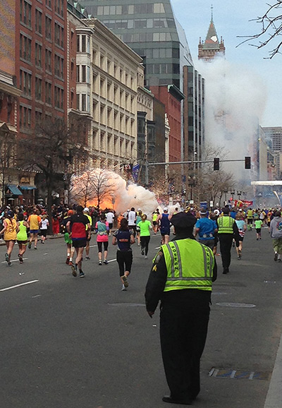 Boston explosions update: Runners continue to run towards the finish line as an explosion takes place