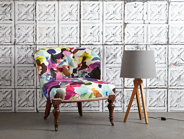 Homes - Chairs: multi-coloured chair with grey lamp against a tiled wallpaper background