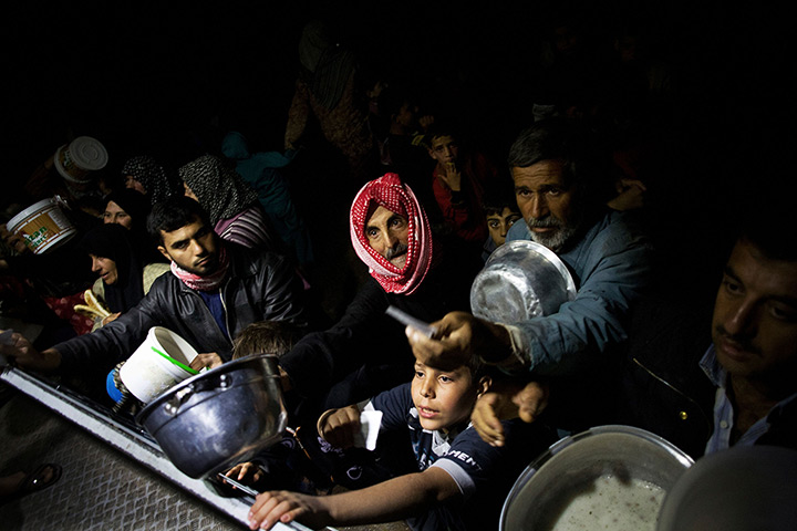 Pulitzer prize: Displaced Syrian men wait for food near an NGO charity kitchen
