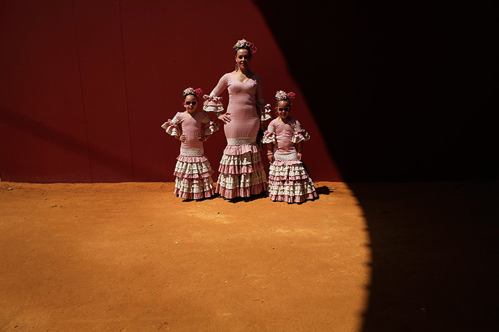 24 hours: Seville, Spain: A woman and her daughters wearing typical Sevillana outfits