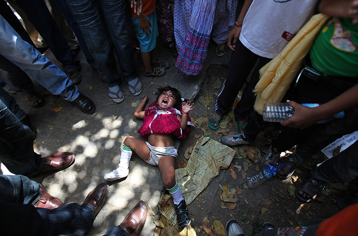 24 hours: New Delhi, India: A girl cries after being flung on the ground