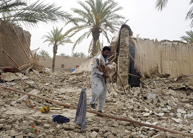 24 hours: Mashkail, Pakistan: An earthquake survivor carries a goat